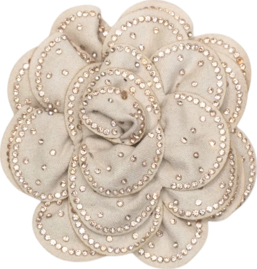 Dettaglio di un fiore avorio in tessuto con piccole perle e cristalli